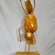 Scultura con caramella color miele come corpo e figura acrobatica capovolta, opera di Pierangelo Bertolo