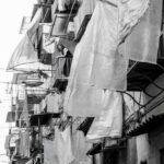 Fotografia in bianco e nero dedicata alla vita quotidiana nei vicoli di Napoli, tra tradizioni, incontri e identità urbana.
