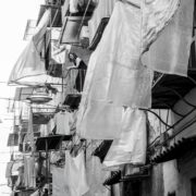 Fotografia in bianco e nero dedicata alla vita quotidiana nei vicoli di Napoli, tra tradizioni, incontri e identità urbana.
