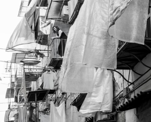 Fotografia in bianco e nero dedicata alla vita quotidiana nei vicoli di Napoli, tra tradizioni, incontri e identità urbana.