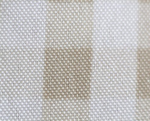 Fotografia macro di Rebecca Levi raffigurante la trama intrecciata di un tessuto chiaro osservato da distanza ravvicinata.